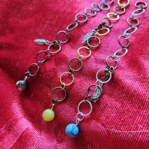 Rød baggrund med forskellige typer af strikkefisk i forskellige farver og forskellige halvædelsten.